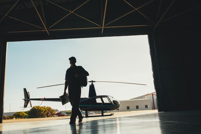 Helicopter pilot in airplane hangar