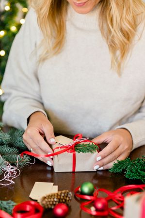 An unrecognizable woman holding Christmas gift in hand