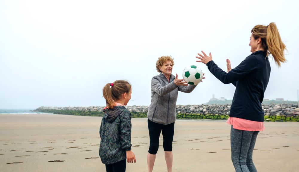 Three generations playing on the beach