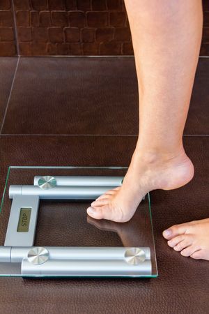 Closeup of woman foot uploading to bathroom scale
