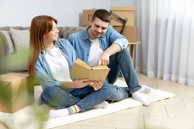 Moving concept, couple man and woman with boxes in apartment.