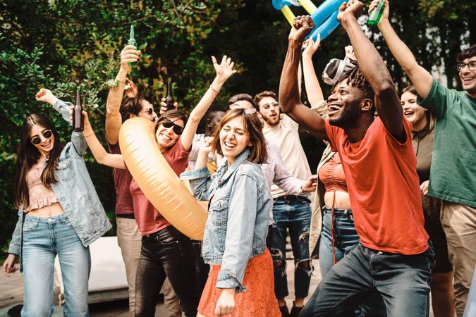 Diverse and playful group of people dancing and socializing together at garden party