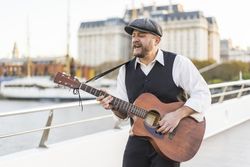 A street musician performing classic songs on guitar.