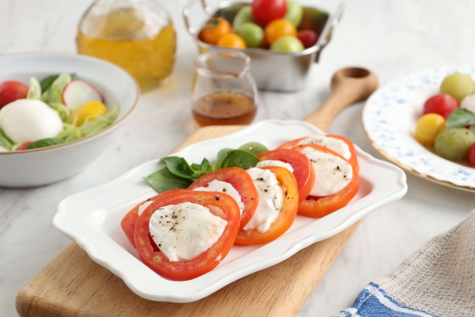 Salad Caprese with Sliced Tomato, Mozzarella Balls, and Basil Leaf