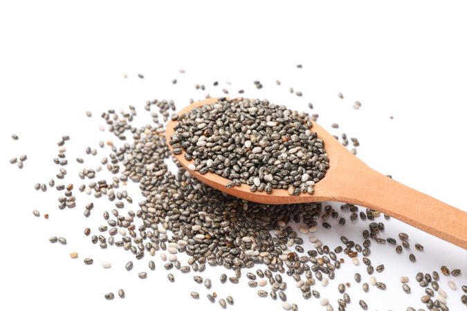 Chia seeds and wooden spoon isolated on plain background
