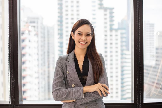 Smiling business woman standing by office window