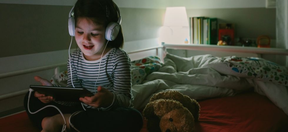 Girl with headphones looking at the tablet