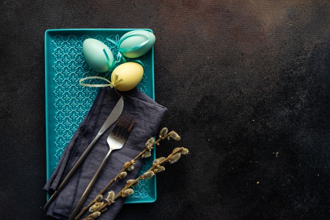 Easter table setting with eggs and pussy willow on rectangular plate