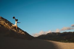 Woman running down sandy hill