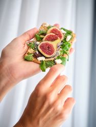 Crop person with delicious fig slices on bread