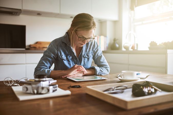 Woman working on tablet in her kitchen