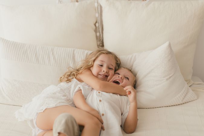 Sister embracing little brother at home