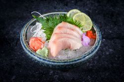 Bowl of sashimi on dark backdrop