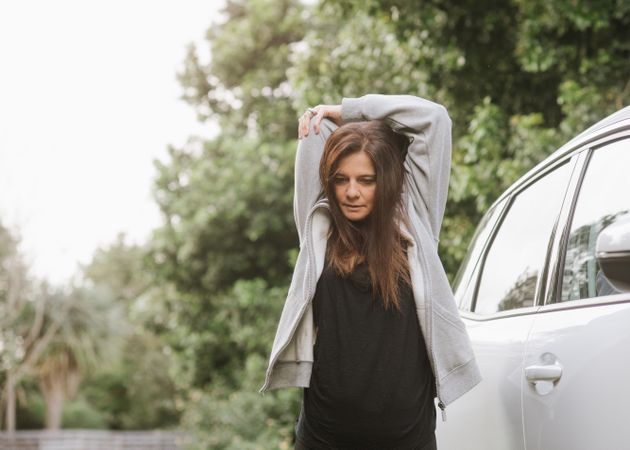 Woman stretching near car in park