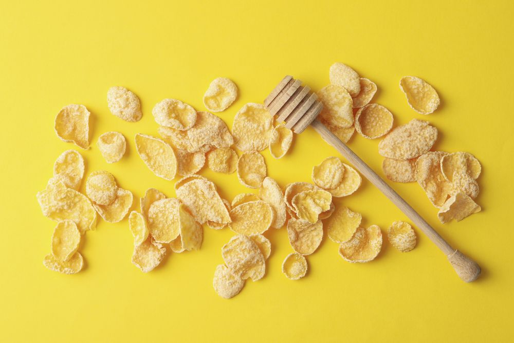 Tasty muesli and dipper on yellow background