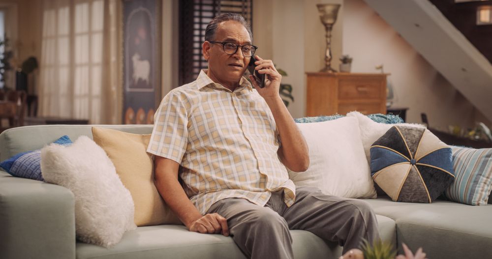 Mature Indian Man Using Smartphone Talks with Loved Ones