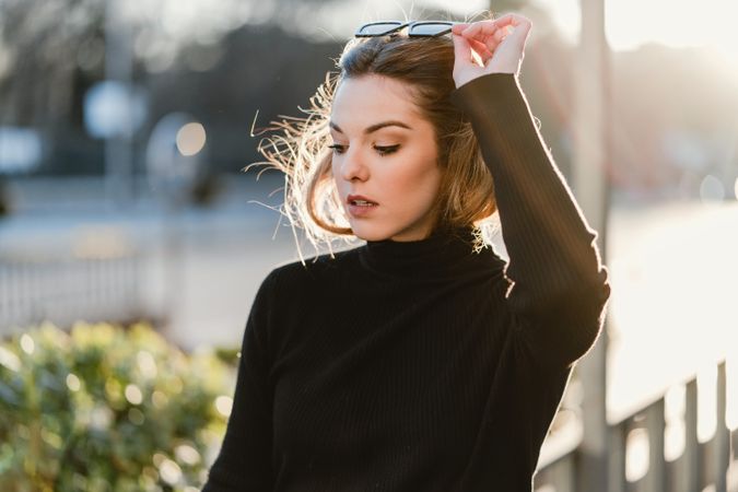 Woman taking off her sunglasses on the street
