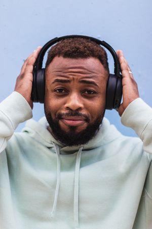 Optimistic Black hipster listening to music with headphones
