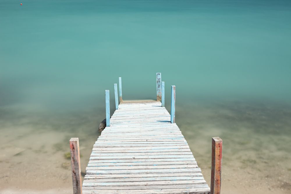 Wooden broken old pier in calm water