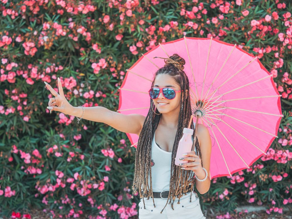 Female with umbrella standing near blooming trees