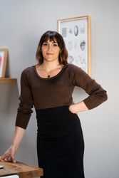Transgender woman in knitted top and skirt posing with hand on hip