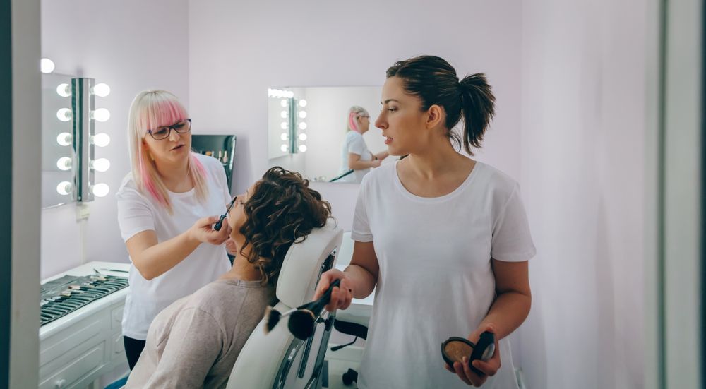 Portrait of make-up artist working with a female customer in a beauty center