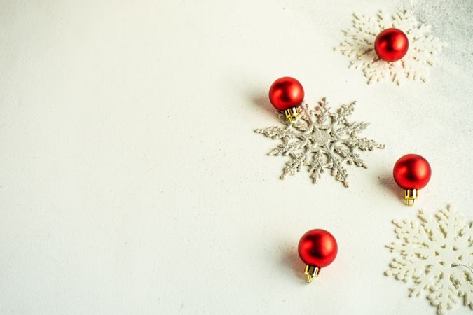 Decorative snow flakes and red baubles with copy space