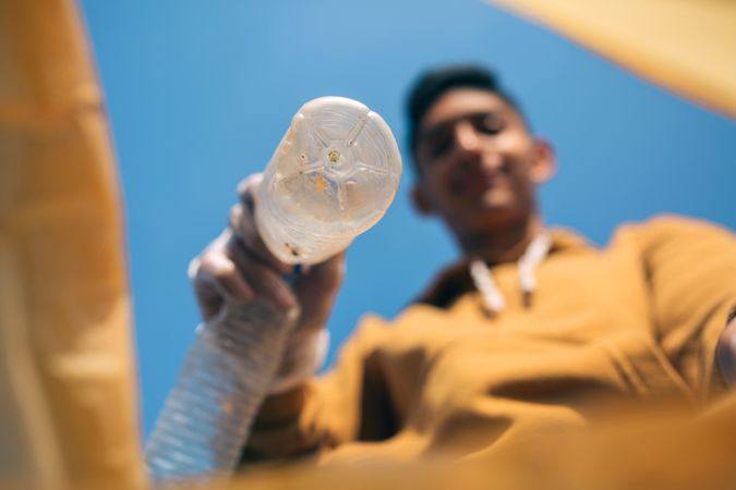 Young man throwing plastic bottles in the trash