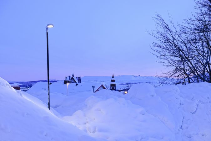 Streetlight in snowy village in evening