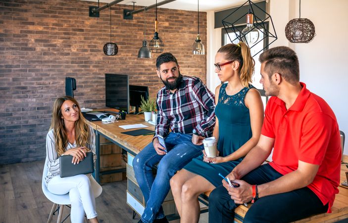 Office workers team talking sitting over the table in coworking