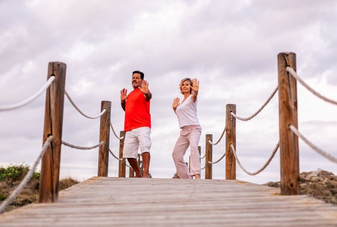 Couple practicing martial arts on lumber path