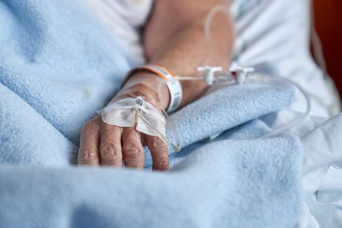 Unrecognizable patient with catheter on hand