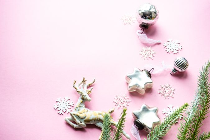Star and reindeer Christmas ornaments on pink background