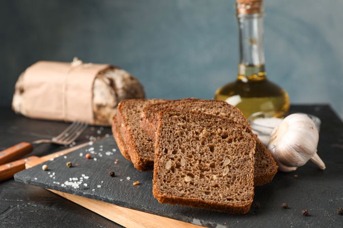 Composition with bread on cutting board, closeup and space for text