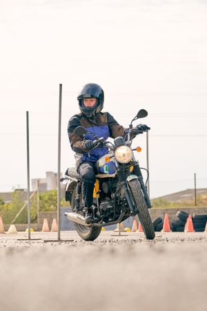Concentrated woman riding motorcycle on motordrome