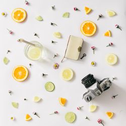 Colorful pattern made of orange, lemon, lime and flowers with lemonade and vintage camera