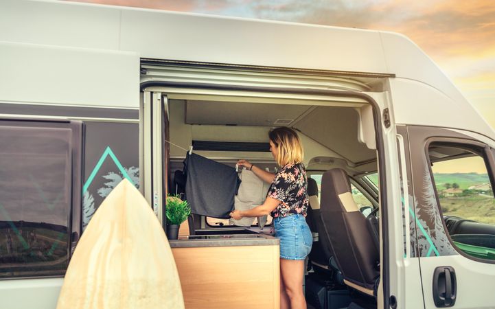Female hanging laundry in small motorhome kitchen