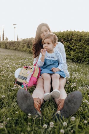 Mother and daughter sitting on lawn