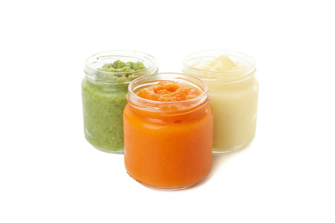 Glass jars with healthy baby food isolated on plain background