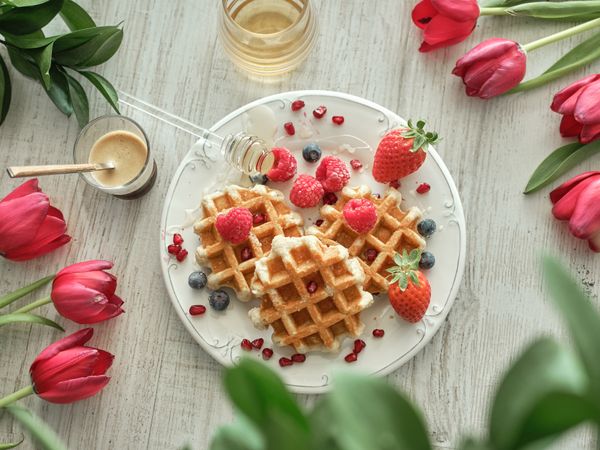 Dessert on plate near flowers and coffee with honey