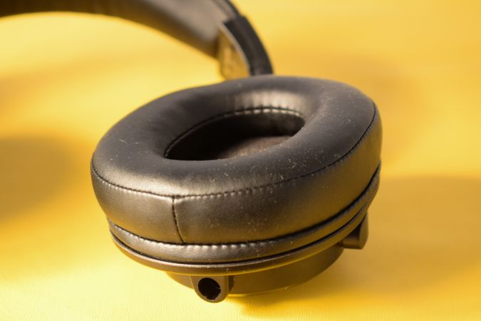 Single headphone ear cushion on yellow table