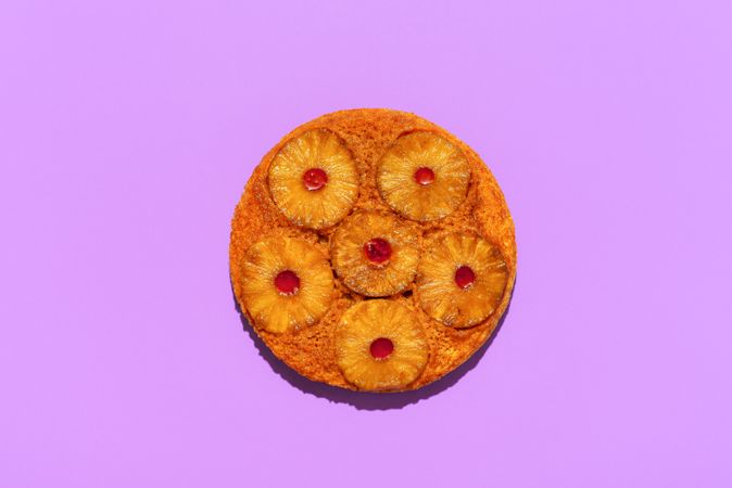 Pineapple cake top view, isolated on a purple background