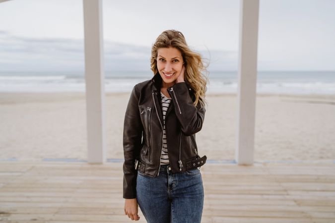 Woman on white wooden pier with ocean on background