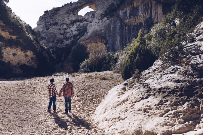 Woman and man standing on stones between high hills