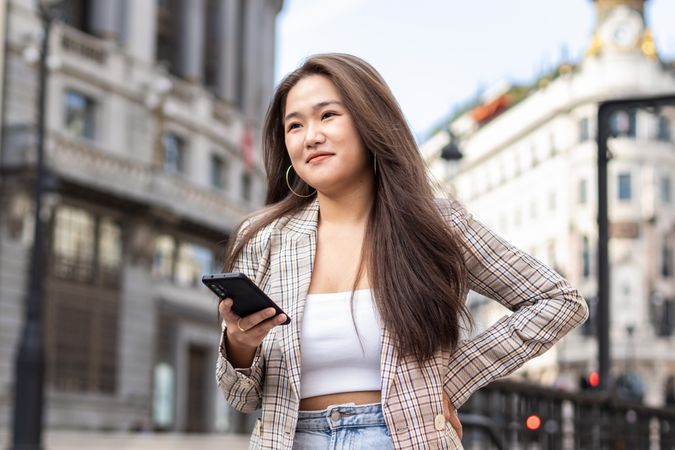 Young Asian Woman Walking and Using Smartphone in the City