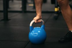 hand of a man taking a kettlebell