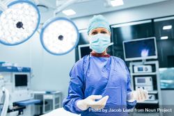 Portrait of surgeon standing in operating room, ready to work on a patient 0LLlP0