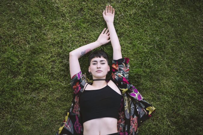 Woman in colored shirt lying on grass