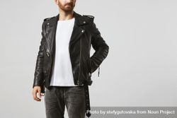 Man in dark leather biker jacket and light t-shirt with hand in pocket 5o6e80
