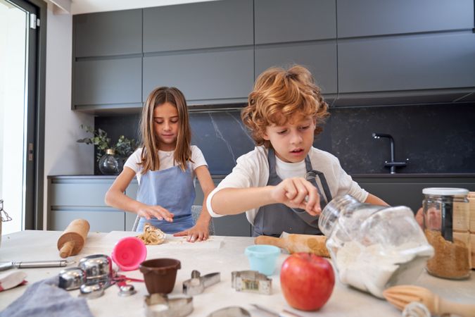 Children making cookies in kitchen